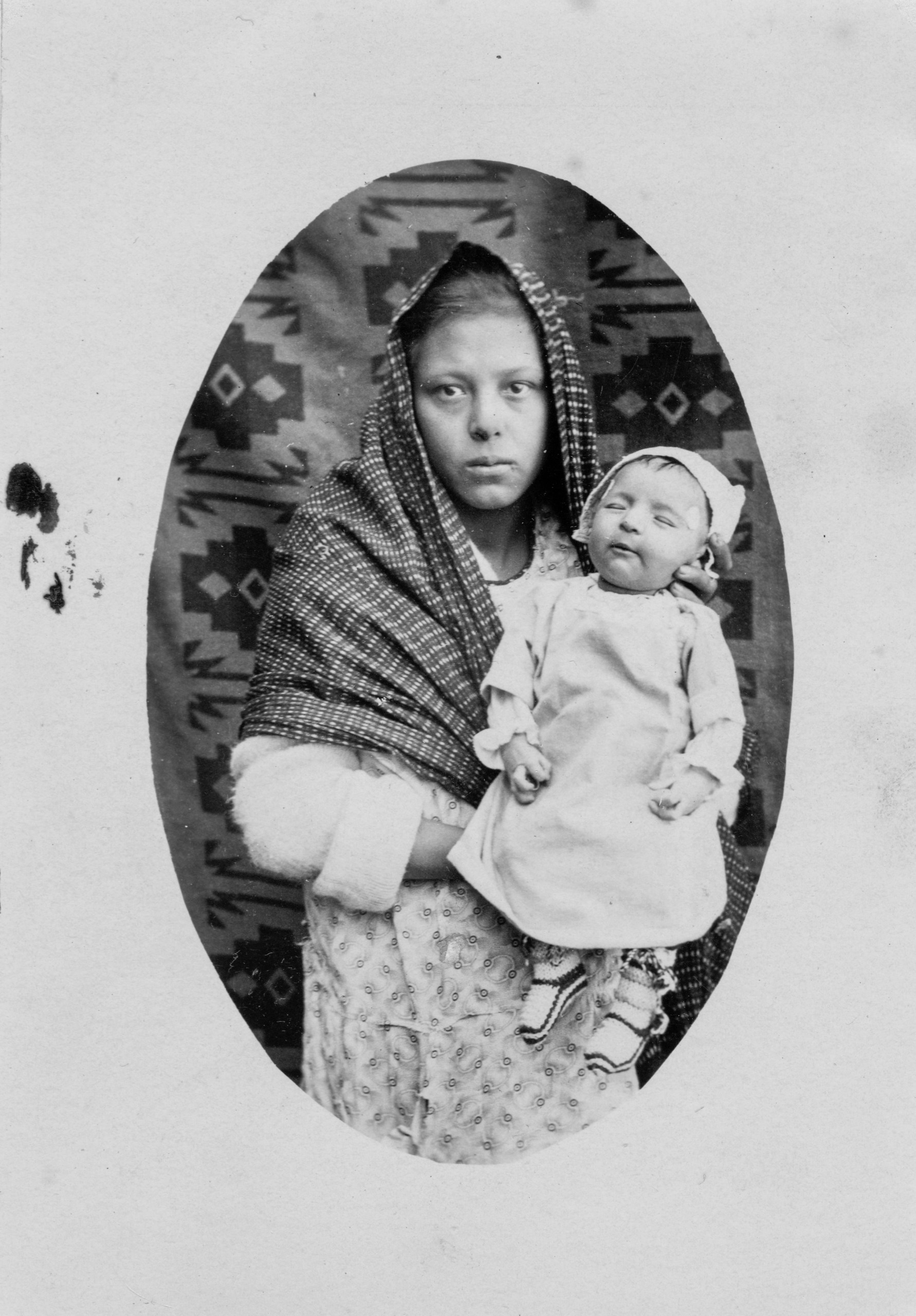 Retrato post mortem infantil sostenido por mujer joven