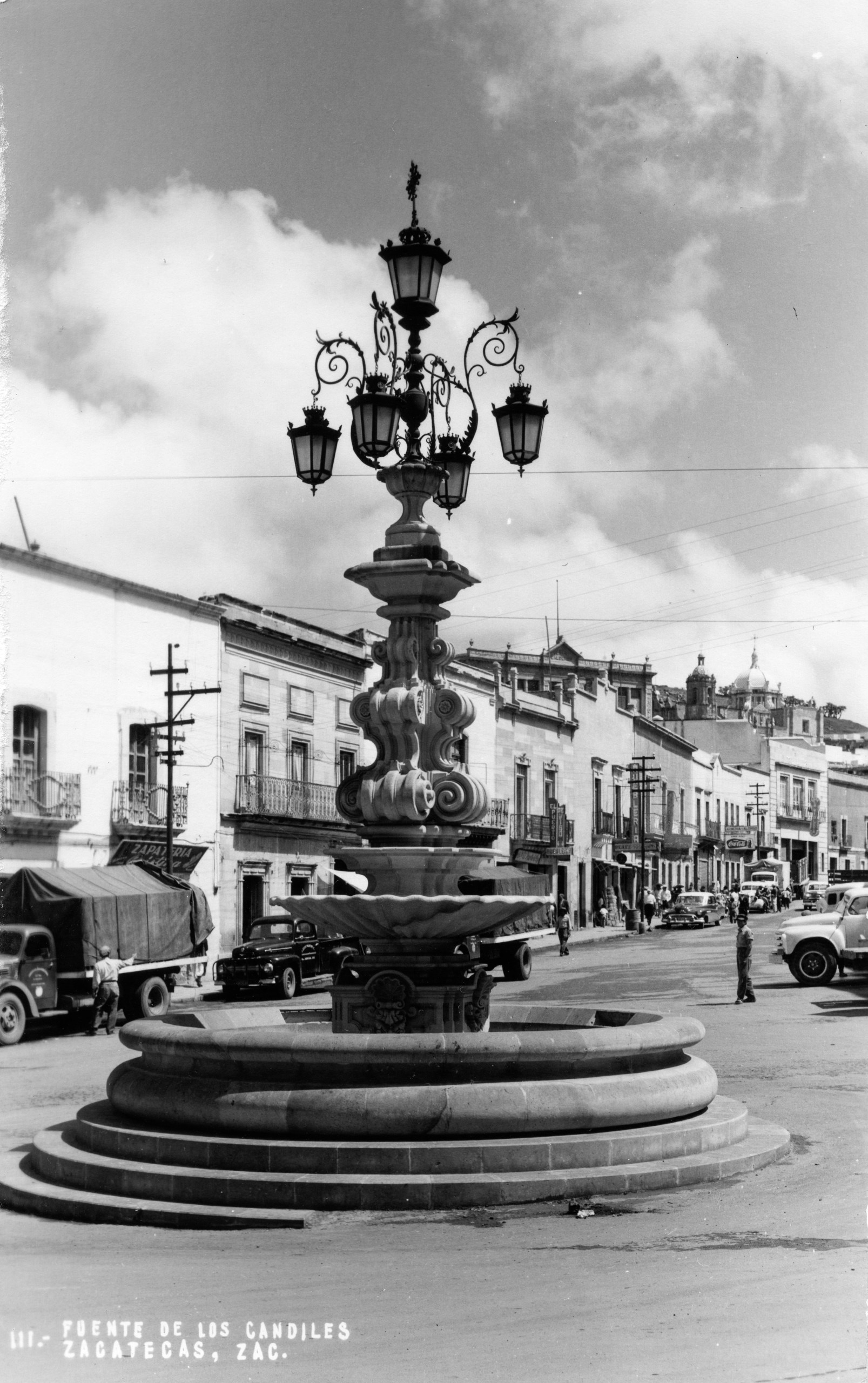 Fuente de los Faroles en espacio urbano con automóviles, mediados del siglo XX