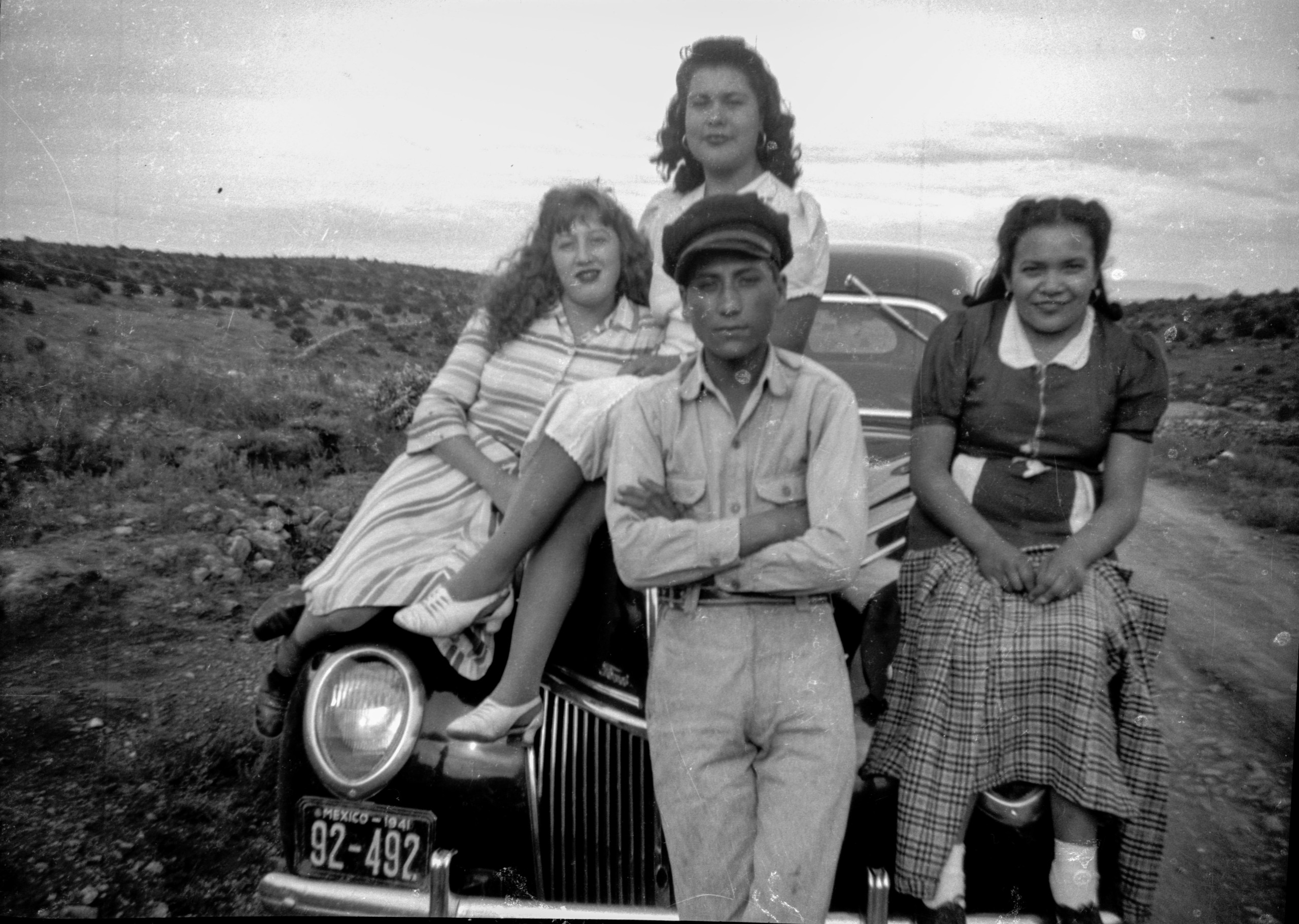 Cuatro personas junto a automóvil en camino rural de Nieves, circa 1941